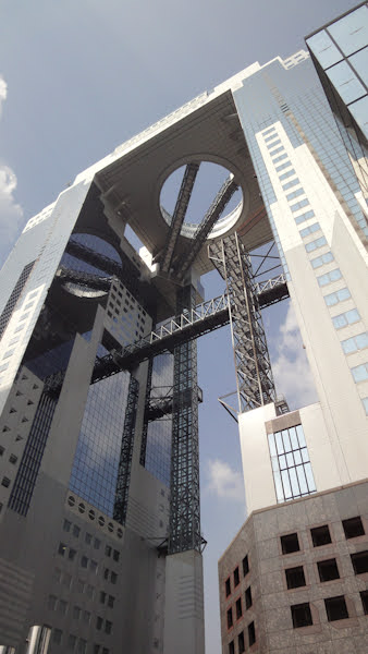 a close view from the ground shows the walkway and escalators that lead from a high floor to the rooftop